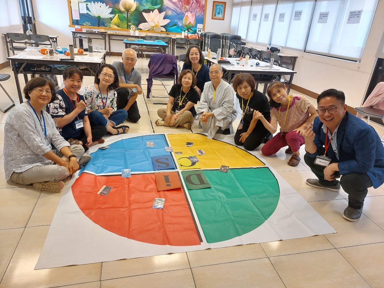 團隊圍繞大型 DISC 四象限教具進行團隊共識工作坊,學員合影互動
